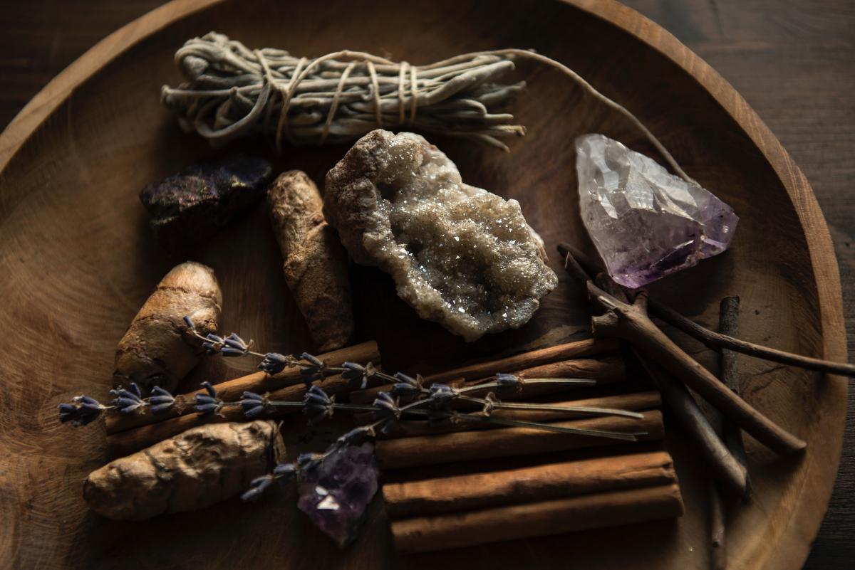 Wooden bowl with herbs in bundles and crystals